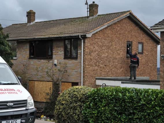 Emergency glaziers work on a house which burned down in Mapplefield near Barnsley, killing one woman and a dog. (Alex Cousins / SWNS.com)