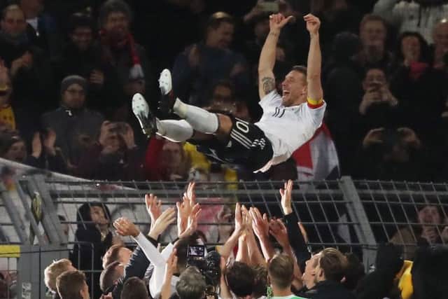 Germany's Lukas Podolski celebrates with team-mates after his final game.