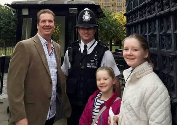 PC Keith Palmer poses for a picture with Andrew Thorogood and his daughters Alexsandra and Georgia outside the Houses of Parliament in October 2016. Picture: SWNS