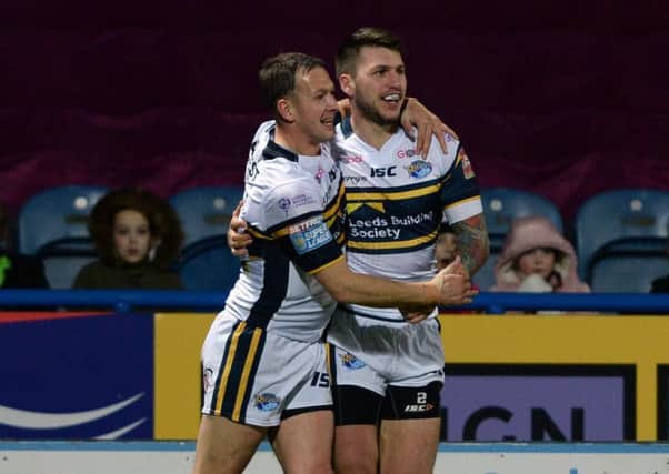 Leeds winger Tom Briscoe celebrates the Rhinos first try against Huddersfield with his captain, Danny McGuire.
