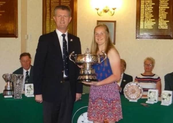 Selby's Megan Garland receives the Yorkshire amateur trophy from then YUGC president Jonathan Plaxton after her victory at Huddersfield last May.