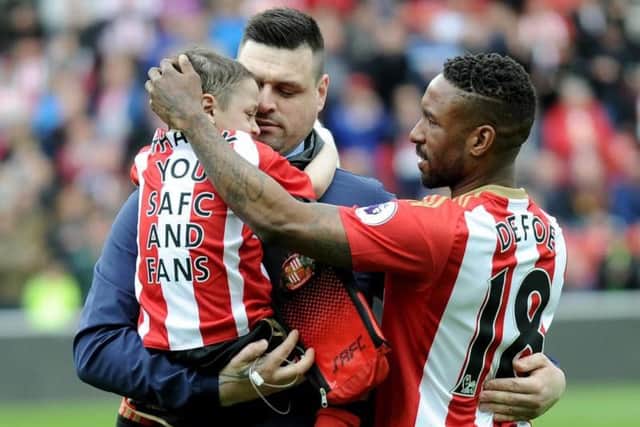 Bradley Lowery is carried by his dad as Jermain Defoe gets ready to start the game against Swansea.