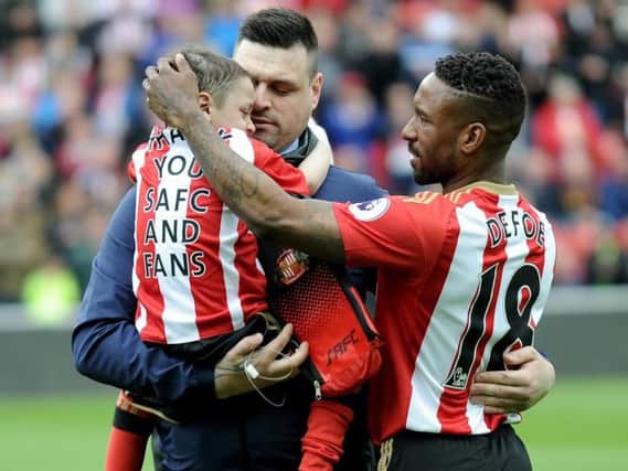 Bradley Lowery is carried by his dad as Jermain Defoe gets ready to start the game against Swansea.