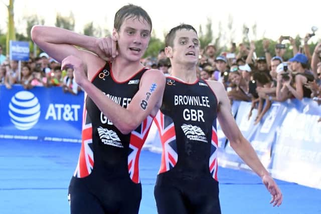 Alistair Brownlee, left, helps his brother Jonny over the line in the triathlon World Series event in Cozumel, Mexico last year.