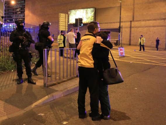 Armed police (left) at Manchester Arena after reports of an explosion at the venue during an Ariana Grande gig. PA