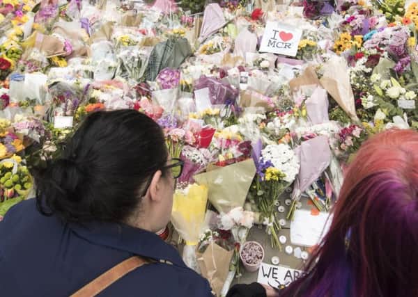 People view floral tributes in St Ann's Square, Manchester. PIC: PA