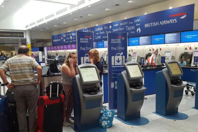 Passengers at the British Airways check-in desk at Gatwick Airport. The airline cancelled all flights leaving from Heathrow and Gatwick yesterday because of a "major IT system failure". PA