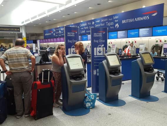 Passengers at the British Airways check-in desk at Gatwick Airport. The airline cancelled all flights leaving from Heathrow and Gatwick yesterday because of a "major IT system failure". PA