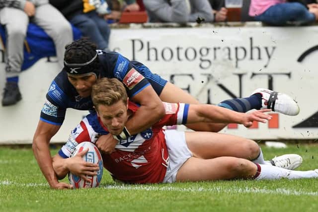 Ashton Golding can't stop Kyle Wood scoring Wakefield's second try.