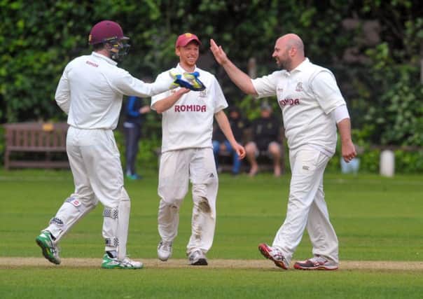 Chris Brice (right), of Woodlands, is congratulated after getting the big wicket of New Farnley's Lee Goddard caught by keeper Greg Finn (left). PIC: Steve Riding