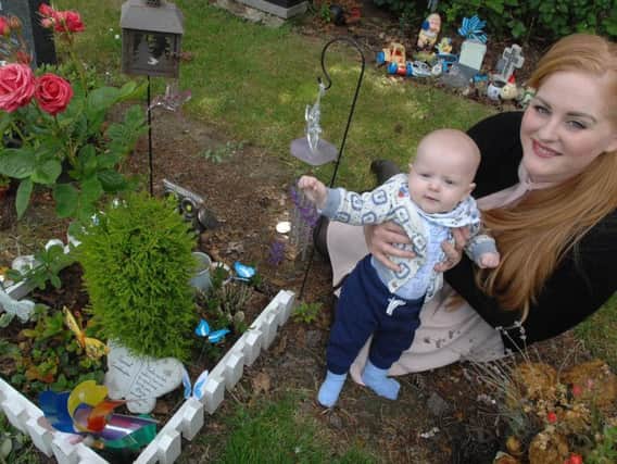 Emma Brothwood with her baby son Ruben sit next to Evelyns little garden in Stonefall. Picture: Adrian Murray