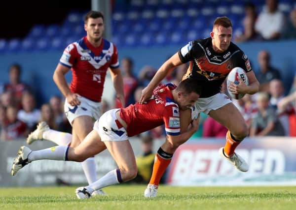Castleford Tigers' Greg Eden is tackled by Wakefield's Sam Williams.