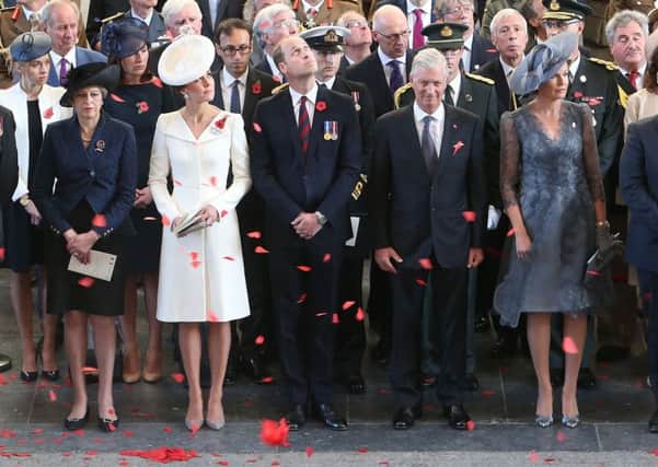 Prime Minister Theresa May (left), the Duke and Duchess of Cambridge King Philippe (third right) and Queen Mathilde (second right) watch as the poppies fall from the roof of the Menin Gate in Ypres, Belgium for the official commemorations marking the 100th anniversary of the Battle of Passchendaele. PRESS ASSOCIATION Photo. Picture date: Sunday July 30, 2017. See PA story MEMORIAL Passchendaele. Photo: Andrew Matthews/PA Wire.