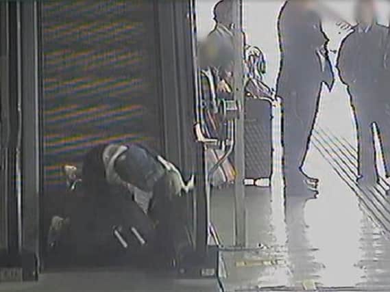 CCTV footage shows a woman falling at Leeds railway station while struggling with heavy luggage.