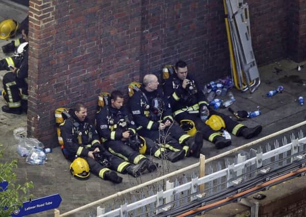 Shattered and exhausterd firefighters at the scene of the Grenfell Tower blaze.