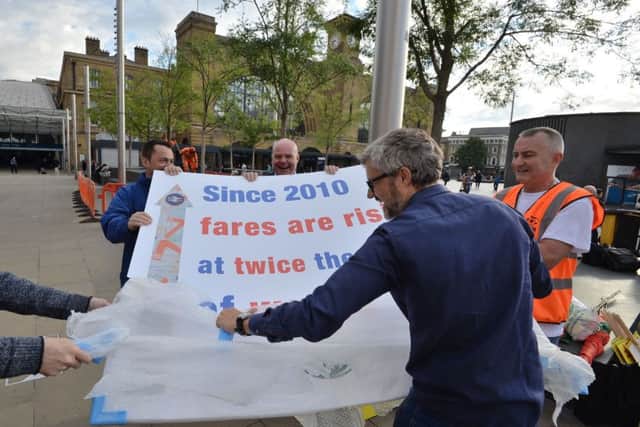 Rail unions and campaigners unveil a banner during a protest against rail fare increases