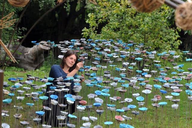 ART ATTACK: Ceramic artist Anna Whitehouse places the last pieces to her instalation made with local schoolchildren and volunteers. PIC: Tony Johnson