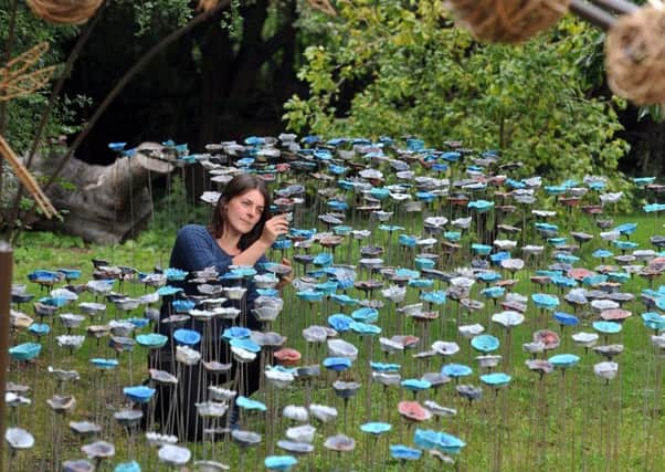 ART ATTACK: Ceramic artist Anna Whitehouse places the last pieces to her instalation made with local schoolchildren and volunteers. PIC: Tony Johnson