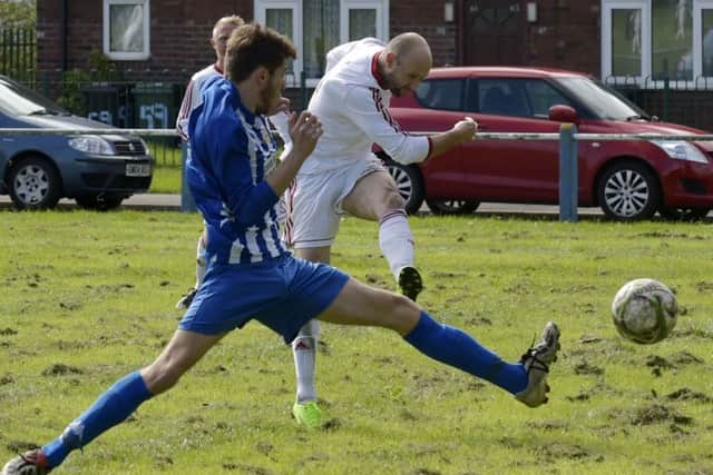 Roy Stammer gets a shot away for Real Moor in their 7-2 away win over Leeds and District FA Senior Challenge Cup hosts Beeston Juniors FC. PIC: Steve Riding