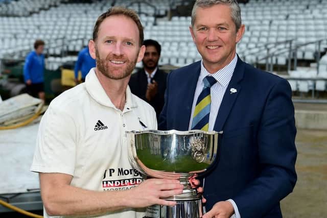 Hanging Heaton captain Gary Fellows receives the Yorkshire Premier League trophy.