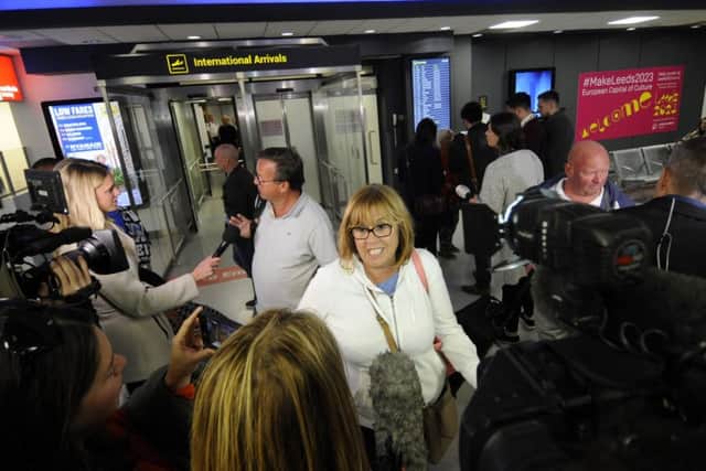 A passenger on the flight from Dalaman is greeted by the waiting media.