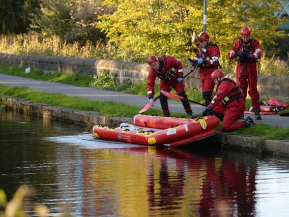 Emergency services work in the canal as they attempt to recover the body