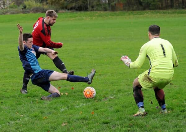 Joe Childerson scores for Rothwell past Sky Blue goalkeeper Craig Wainwright in Division 1. 
Sky Blue beat leaders Rothwell 4-3. PIC: Steve Riding