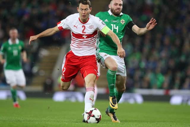 Switzerland's Stephan Lichtsteiner (left) and Northern Ireland's Stuart Dallas battle for the ball during last night's 1-0 defeat for the Irish.