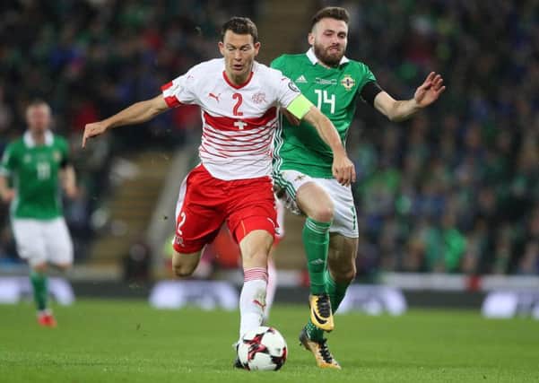 Switzerland's Stephan Lichtsteiner (left) and Northern Ireland's Stuart Dallas battle for the ball during last night's 1-0 defeat for the Irish.