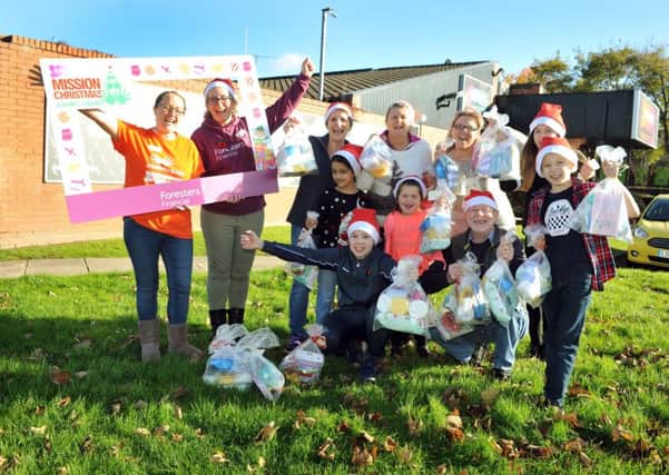 Fundraiser Lauren Scarth, left, with volunteers from financial organisation Foresters pack childrens presents for Mission Christmas at Radio Aire. Picture Tony Johnson.