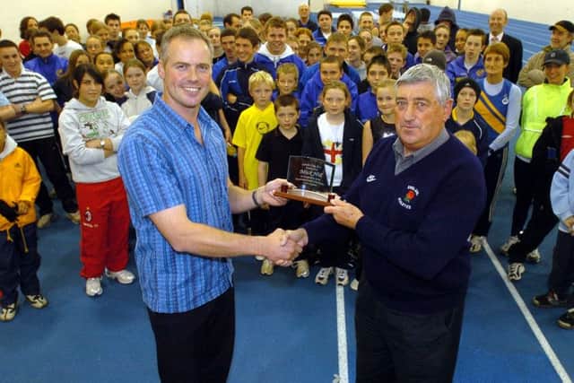 Mick Hill is presented with his lifetime achievement award by Ray Barrow (Life Vice-President of Leeds City Atletics Club), watched by the club's next generation of athletes, back in 2004.