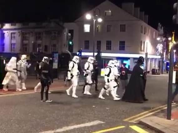 Stormtroopers following Darth Vader through Leeds.