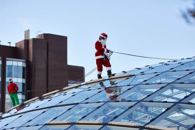 Santa and his elf made an early appearance to help clean the huge glass windows at Trinity Leeds. Image by Simon Kirk