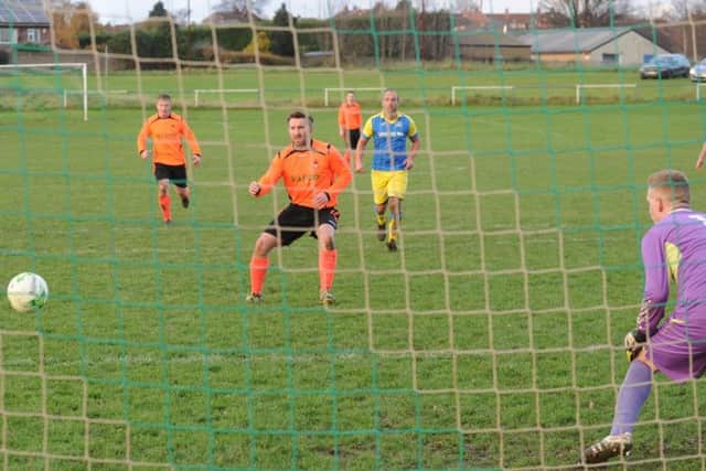 Hall Green United's Mick Amos scores from the penalty spot for the third goal - and his second - past Swillington goalkeeper Tom Day. PIC: Steve Riding