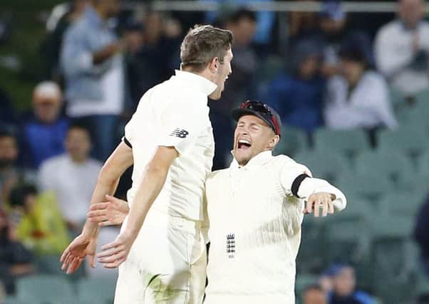 England's Craig Overton celebrates with Joe Root after he took the wicket of Steve Smith. Picture: Jason O'Brien/PA