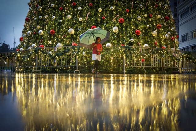 A young Malaysian girl walks in front of a Christmas tree at a mall in Kuala Lumpur, Malaysia. The spirit of Christmas is felt very much in Muslim-dominated Malaysia, as shopping malls  decorate their premises with Christmas trees, lights, Santa Claus and carols as a chance to boost year-end sales. (AP Photo/Joshua Paul)