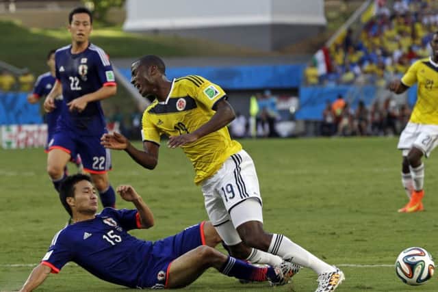 Japan's Yasuyuki Konno battles with Colombia's Adrian Ramos in a Group C clash at the 2014 World Cup. Picture: AP/Thanassis Stavrakis