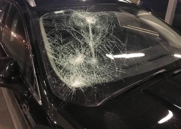 The smashed in windscreen of the police car