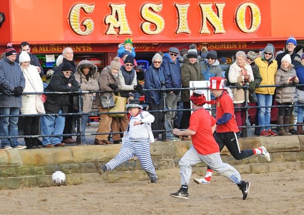 HEAD GAMES: Players in the charity football match wearing top hats on Scarborough South Beach.  PIC: Paul Atkinson