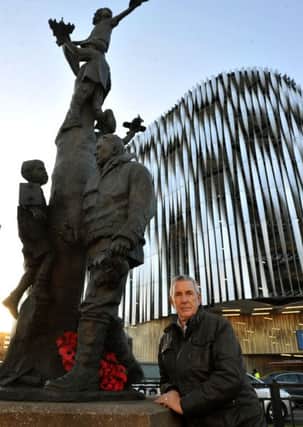 Stewart Manning next to the Arthur Aaron statue on the roundabout at the bottom of Eastgate in Leeds.