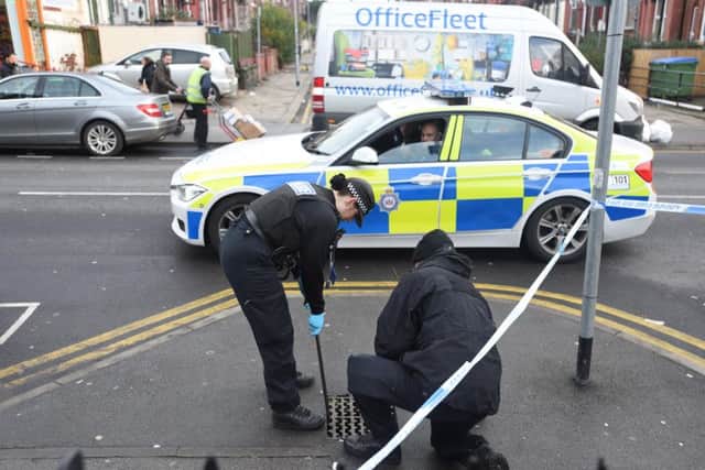 SCOURING THE SCENE: Officers look for clues in a drain. PIC: Guzelian