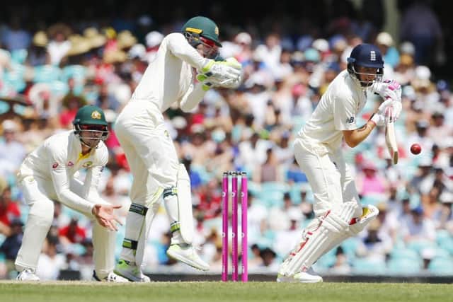 Defiant: England's Joe Root plays a shot as Tim Paine looks on during day four of the Ashes Test at Sydney.