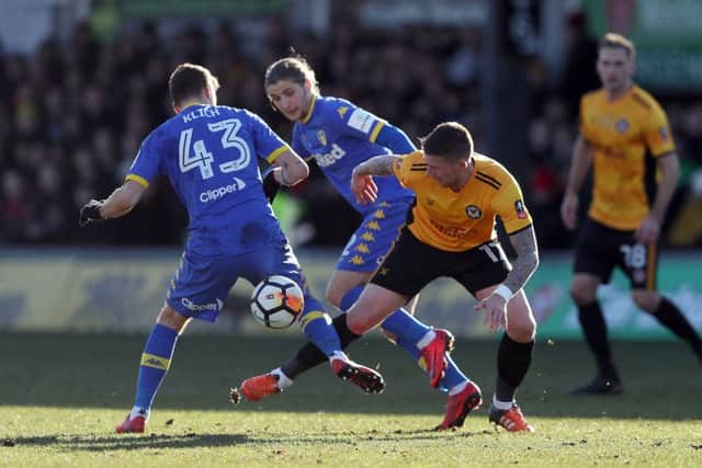 Newport County's Scot Bennett (right) and Leeds United's Mateusz Klich battle for the ball at Rodney Parade. Picture: David Davies/PA