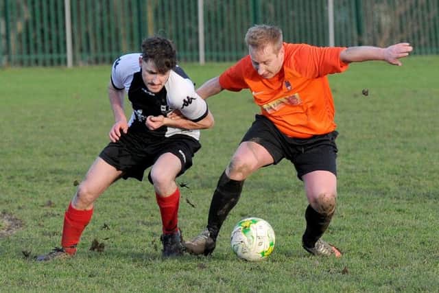 Joe Entwhistle, of Wyke Wanderers, tussles with Wetherby Athletic's Paul Hustwit. PIC: Steve Riding