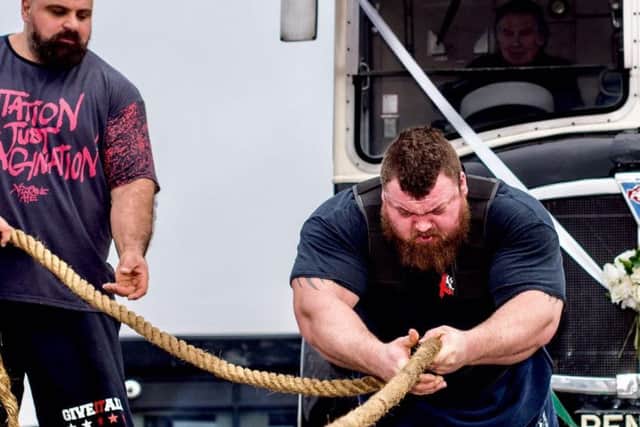 Heave ho! Pulling an eight-tonne bus in a Leeds car park is 'The Beast' Eddie Hall - encouraged by Europes Strongest Man, Laurence Shahlaei.