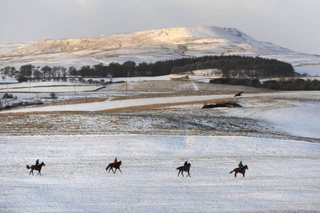 The Pennine hilltops are covered with snow as riders make their way onto the gallops at Middleham Moor near Leyburn, as yellow snow and ice warnings are in place for northern England and Northern Ireland and much of Wales. PRESS ASSOCIATION Photo. Picture date: Wednesday January 17, 2018. See PA story WEATHER Cold. Photo credit should read: John Giles/PA Wire