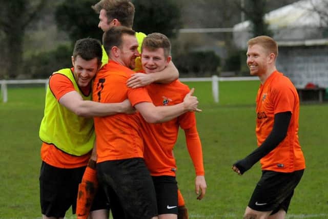 Otley Town team-mates swarm around match-winner Jonathon Unwin after scoring the penalty that put Hunslet Club out of the League Cup. It was 1-1 after regular time with Town going through 5-4 on penalties. PIC: Steve Riding