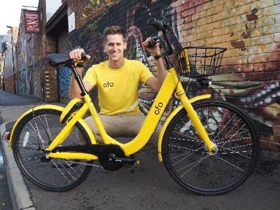 Adam Rose, Ofo operations manager for Sheffield, pictured with an Ofo bike.