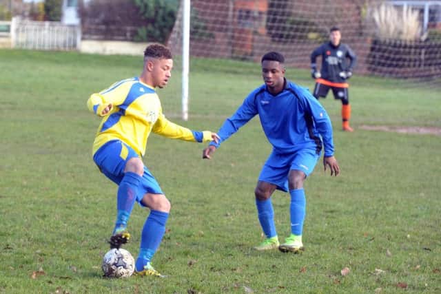 Main Line's Bradley Frances-White holds up the ball as Kwame Boateng, of Whitkirk Wanderers, closes in. PIC: Tony Johnson