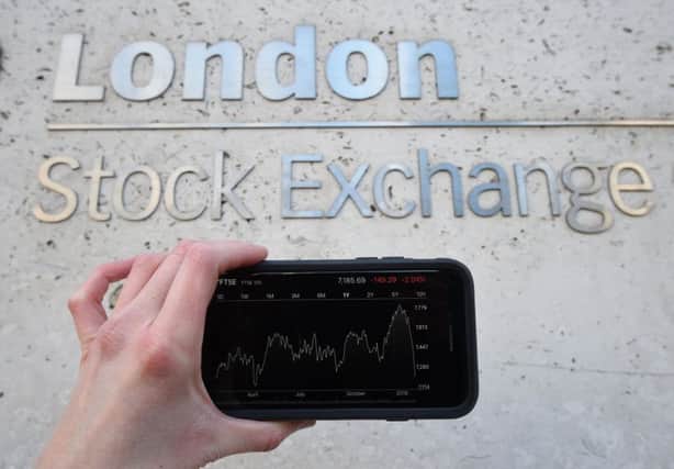 A view of the Stocks app on an iPhone against the London Stock Exchange sign in the City of London, as the FTSE 100 Index crashed on opening by more than 230 points to 7,104.94 as inflation fears continue to rock global markets. PRESS ASSOCIATION Photo. Picture date: Tuesday February 6, 2018.Photo: Kirsty O'Connor/PA Wire